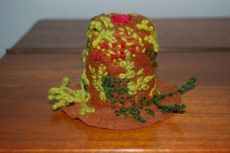 Mini hatte syet af filt med pynt og broderi.