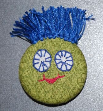 Magneter og knapper med håndbroderi. Håndværk og design.