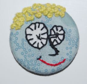 Magneter og knapper med håndbroderi. Håndværk og design.