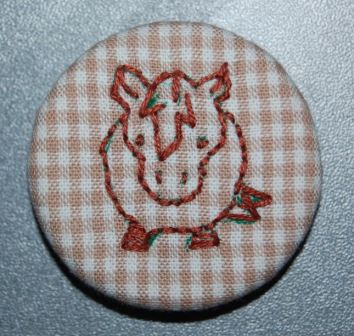 knapper og magneter med håndbroderi. Håndværk og design.