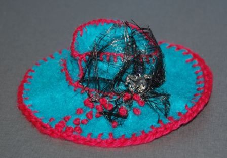 Mini hatte syet af filt med pynt og broderi.