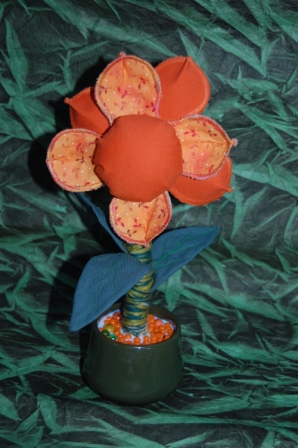 Orange blomst som nålepude. en tekstil opgave til håndværk og design.